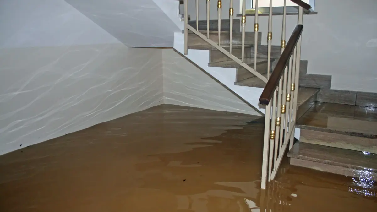 Flooded lower level with water covering the floor and staircase